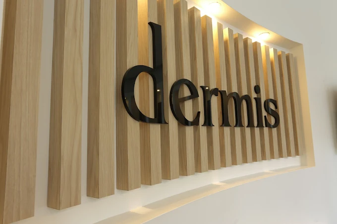 Dermis logo on backlit wood slat wall